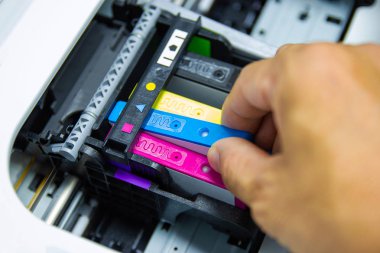 Teknisyenler renkli yazıcı inkjet kartuşu kurarken