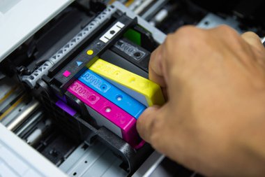 Teknisyenler renkli yazıcı inkjet kartuşu kurarken