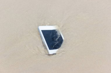 Sahilde denize yüzen beyaz cep telefonu.