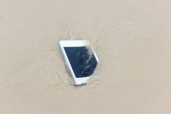 Telefone celular branco flutuou para o mar na praia . — Fotografia de Stock