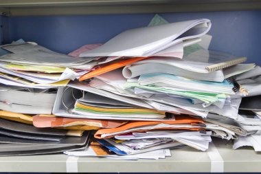 Çalışma ofisindeki dosya dolaplarında dağınık dosya ve ofis malzemeleri 