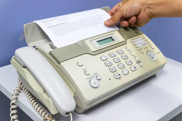 Ręka człowiek używa faksu w biurze — Zdjęcie stockowe