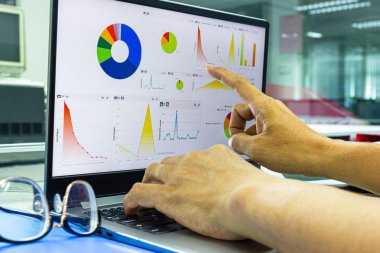 iş adamı çalışma ofisinde ekranda grafik ile dizüstü bilgisayar üzerinde çalışıyor