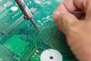 Teknisyenler elektronik tamir için bir lehimleme demir kullanıyor 