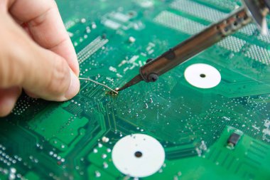 Teknisyenler elektronik tamir için bir lehimleme demir kullanıyor 