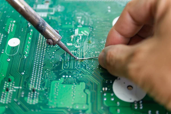 Teknisyenler elektronik tamir için bir lehimleme demir kullanıyor 