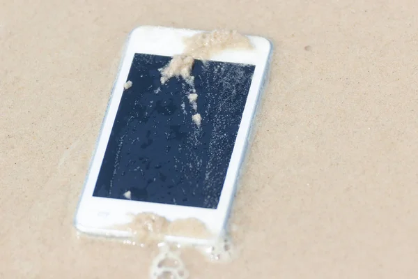 Telefone celular branco flutuou para o mar na praia . — Fotografia de Stock
