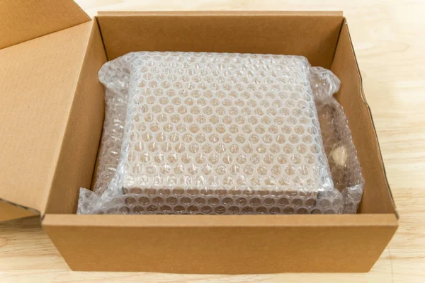 Bubliny zakrývající krabici pomocí bublinového obalu pro ochranný přípravek — Stock fotografie