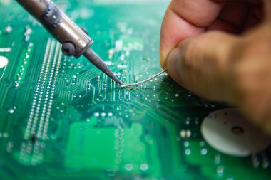 Teknisyenler elektronik tamir için bir lehimleme demir kullanıyor 