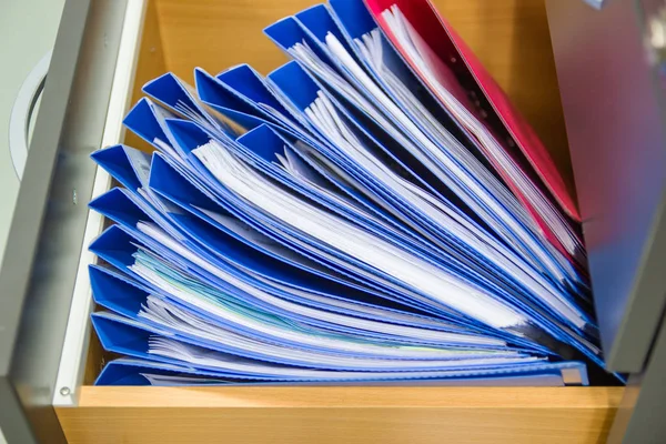 Documentos de pasta de arquivo azul Em uma retenção de gabinete de arquivos — Fotografia de Stock