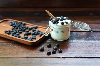 ahşap masalarda cam yoğurt ile taze Yaban Mersini
