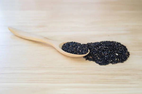 Semillas Sésamo Negro Una Pila Cuchara Madera Sobre Una Mesa —  Fotos de Stock