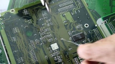 Teknisyenler bilgisayar devresi donanımının elektronik devre konseptini tamir etmek için lehim makinesi kullanıyorlar..