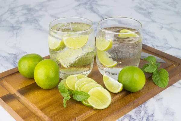 Cold Drink from Lemon cut into pieces in water glass on wood cup