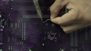 Teknisyenler bilgisayar devresi donanımının elektronik devre konseptini tamir etmek için lehim makinesi kullanıyorlar..