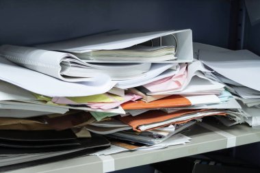 Çalışma ofisindeki dosya dolaplarında dağınık dosya ve ofis malzemeleri 