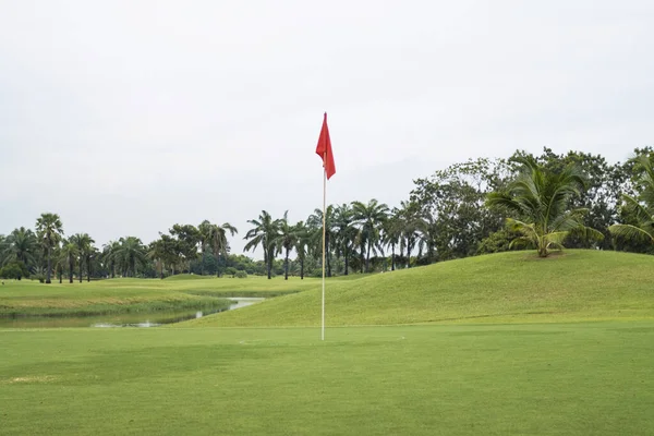 緑のゴルフコースの芝生の上の赤い旗 — ストック写真