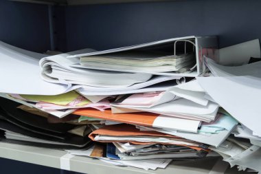 Çalışma ofisindeki dosya dolaplarında dağınık dosya ve ofis malzemeleri 