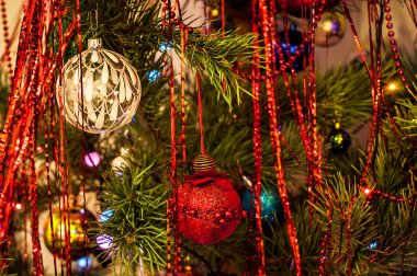 Farklı renkler ve tinsel topları ile süslenen Noel ağacı