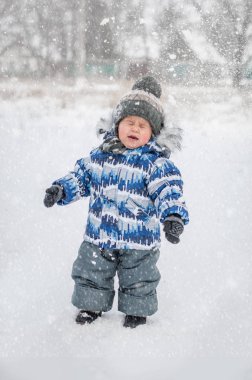 Kar bebek yüzüne uçar. Karlı gün kartopu oynarken küçük çocuk