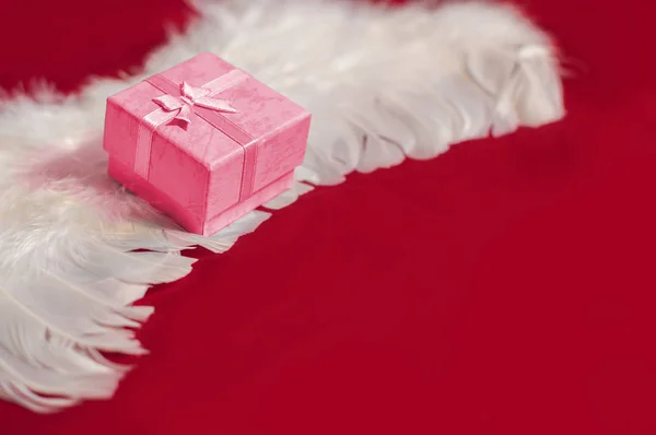 Caja Regalo Roja Alas Plumas Ángel Blanco Fondo Romántico Rojo —  Fotos de Stock