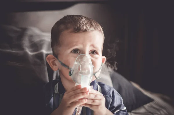Menino de dois anos fazendo inalação com nebulizador em casa . — Fotografia de Stock