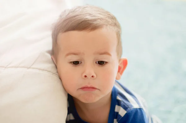 Portrait of 2 year old boy with a sad face expression