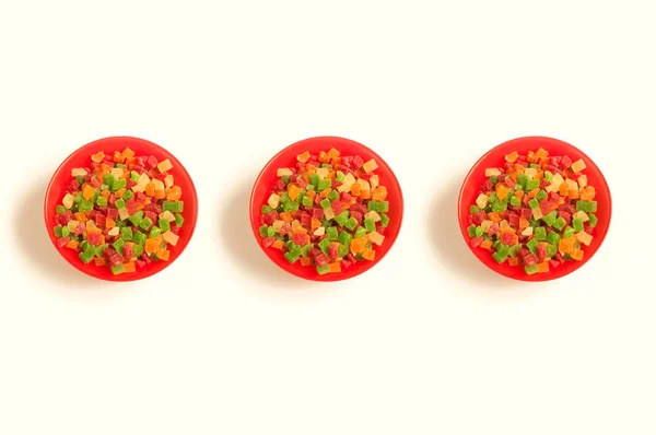 Red round plate full of colorful delicious candied fruits — Stock Photo, Image