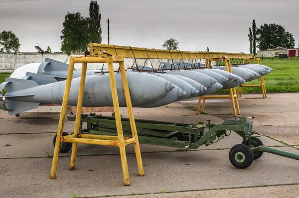 Aerial bombs fixed in line at military airfield.