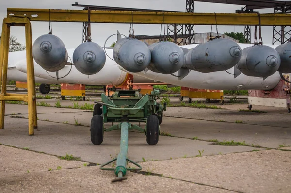 Aerial bombs fixed in line at military airfield.