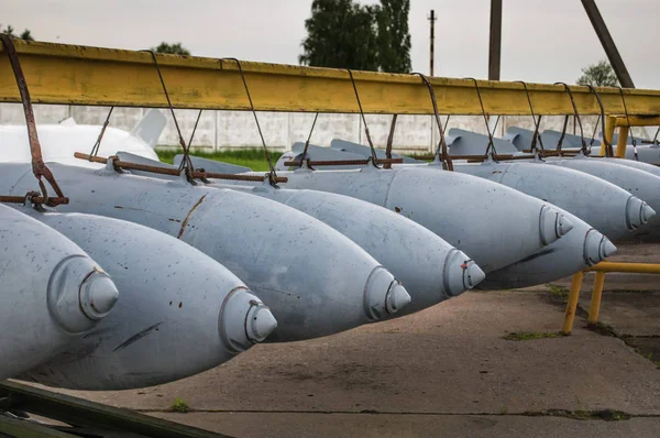 Aerial bombs fixed in line at military airfield.