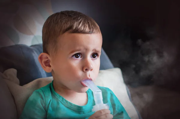 Tre år gammal pojke gör inandning med nebulisator hemma. — Stockfoto