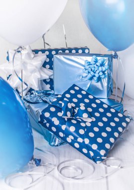 Oda mavi, beyaz ve gümüş baloons ile bir doğum günü partisi için dekore edilmiş, kutuları ve kurdeleler sunar.