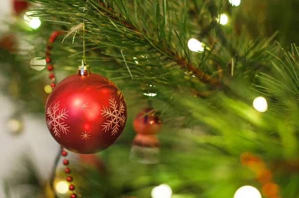 Red christmas ball with a snowflake hanging on a christmas tree Stock Picture