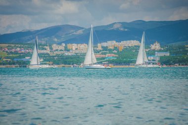 06 Ağustos 2019, Gelendgik, Rusya. Üç beyaz güzel yelkenli turistlerle körfezde seyahat ediyor..