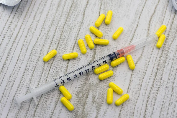 İlaç tablet, kapsül, hap renkli soyut Sarı zemin üzerine düzenlenmiştir. Aspirin, ampül, boş şırınga iğne. Sağlık, tedavi, seçim, sağlıklı yaşam konsepti. Kopya alanı