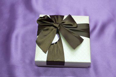 Parlayan parti ışıkları hediye kutuları arka plan bokeh karşı büyük bir kırmızı yay ile. Lüks yeni yıl hediyesi. Noel hediyesi. Noel hediye kutusu ile arka plan. Noel Kutlamaları