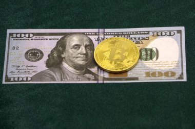 Yüz dolar faturaları üzerinde bir Bitcoin. Closeup makro çekim