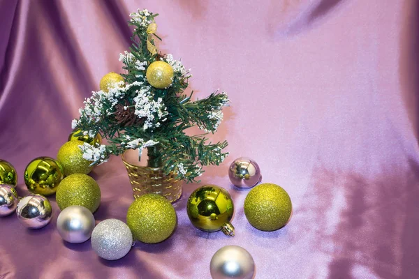 Pembe balonlar, kurdeleler, kar taneleri ve onları altında oyuncaklar ile süslenen Noel ağacı.