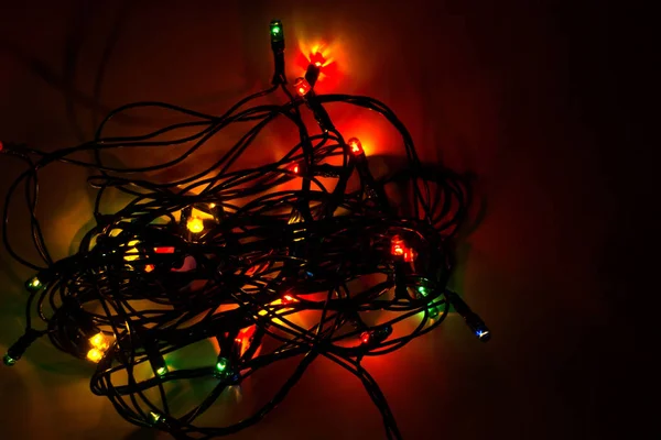 Koyu renkli Noel arka plan, garland ışıklar parlak baubles ve tinsel ahşap zemin üzerinde