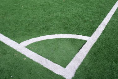 Kırmızı bayrak köşesinde yeşil suni çim futbol sahası içinde tekme