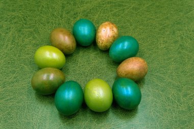 Renkli yumurta ve çiçek mavi zemin üzerine yapılmış yaratıcı Paskalya düzeni. Daire çelenk düz lay kavramı