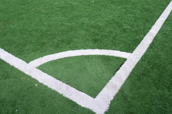 Kırmızı bayrak köşesinde yeşil suni çim futbol sahası içinde tekme