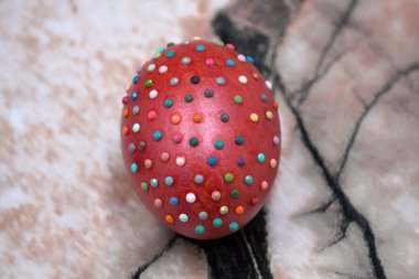 Paskalya yumurta yumurta satırlarındaki beyaz arka plan üzerinde izole iş parçacığı ve beyaz boncuk ile dekore edilmiştir. Paskalya sembol ve dekor. Paskalya günü ve gelenekleri kavramı. Paskalya yumurtası parlak mor renkli, yakın çekim