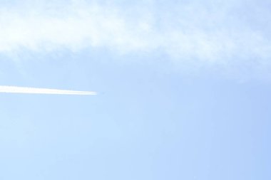 Uçak gökyüzünde uçuyor. Uçağın içinde buharı iz mavi bir gökyüzü. Jet iz.