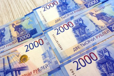 Elini iki bin ruble yeni bir Rus banknot yeşil para makinesi arka planı tutar.