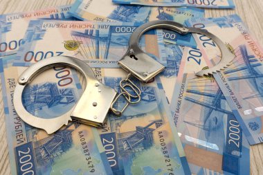 Amerikan Doları arka plan Rus ruble banknotlar katlanmış yığını ile yatan çelik polis kelepçe