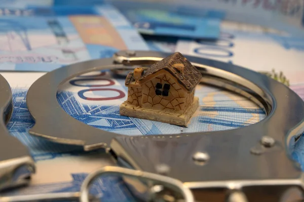 beyaz küçük kağıt ev para altın sikke, taşınmaz kavramı ile güvenli kredi para zinciri ile bağlı, seçici odak, koyu arka plan bulanık, yakın