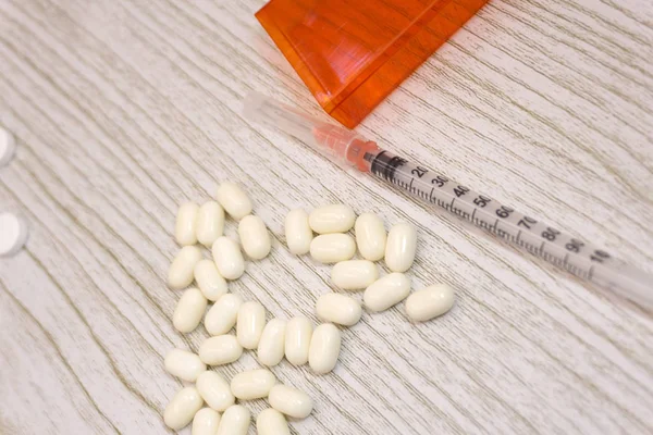 Opioid salgın, uyuşturucu istismarı konseptiyle closeup iki eroin şırınga veya diğer uyuşturucu dağınık reçete opioidler tarafından çevrili. Oksikodon opioid bir dizi için genel adıdır