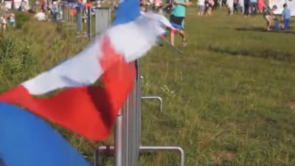 围栏上的五彩旗帜缓缓移动在野餐区的防风铁丝网 — 图库视频影像